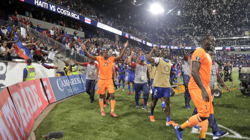 Haiti futbola izlases spēlētāji svin uzvaru pār Kostariku un pirmās vietas iegūšanu B grupā. Foto: Julio Cortez/AP/Scanpix