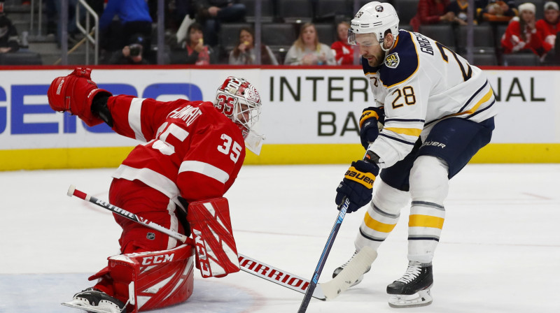 Zemgus Girgensons apspēlē Detroitas "Red Wings" vārtsargu Timu Hovardu. Foto: Paul Sancya/AP/Scanpix